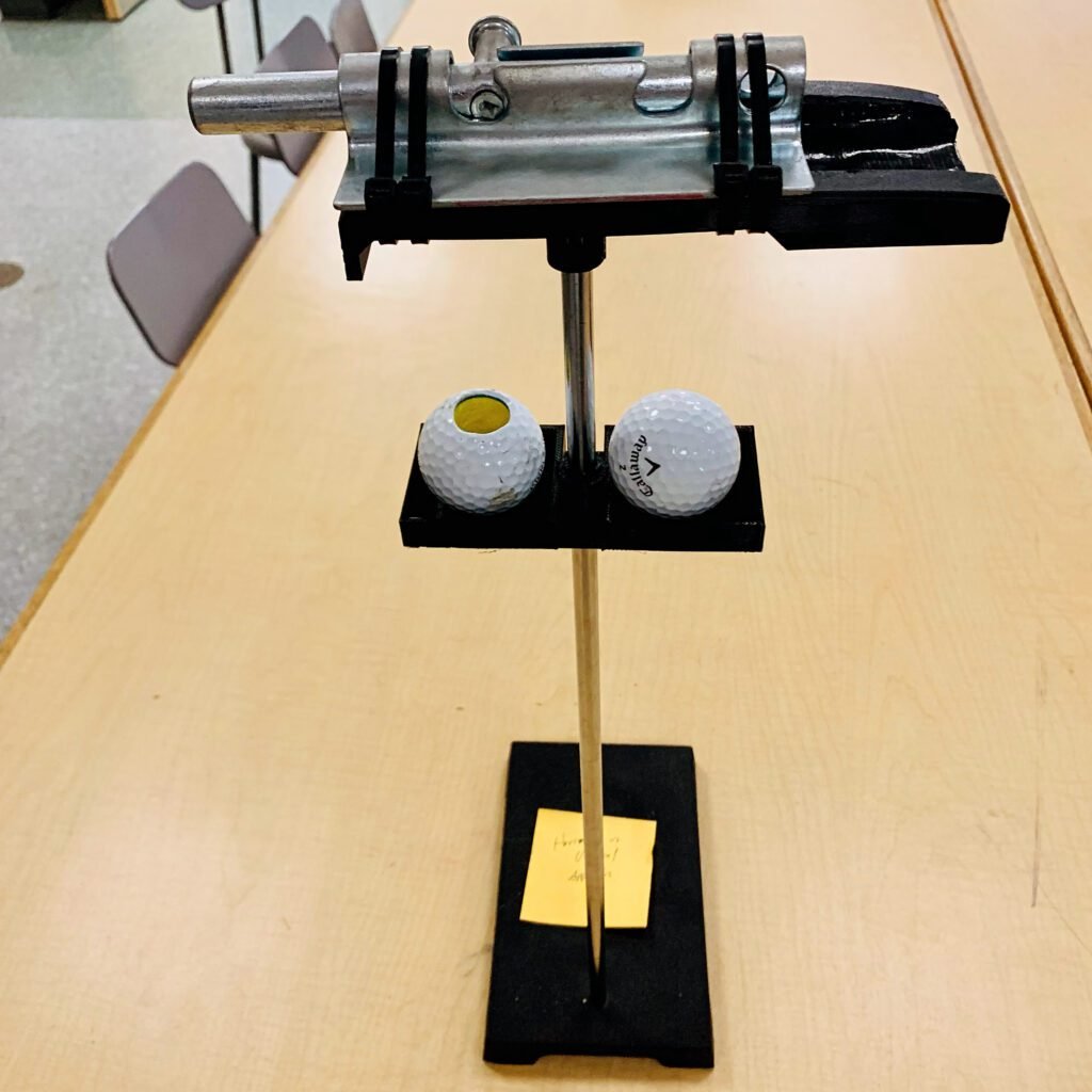 DIY Physics demo tool. A 3D printed golf ball launcher and dropper. I built it using a gate latch which is zip tied to the custom base I designed. one golf ball lays on a platform and gets launched while the other has the gate latch rod inside of it and gets dropped (golf ball with a hole). The whole platform attaches to a chemistry clamp stand. 