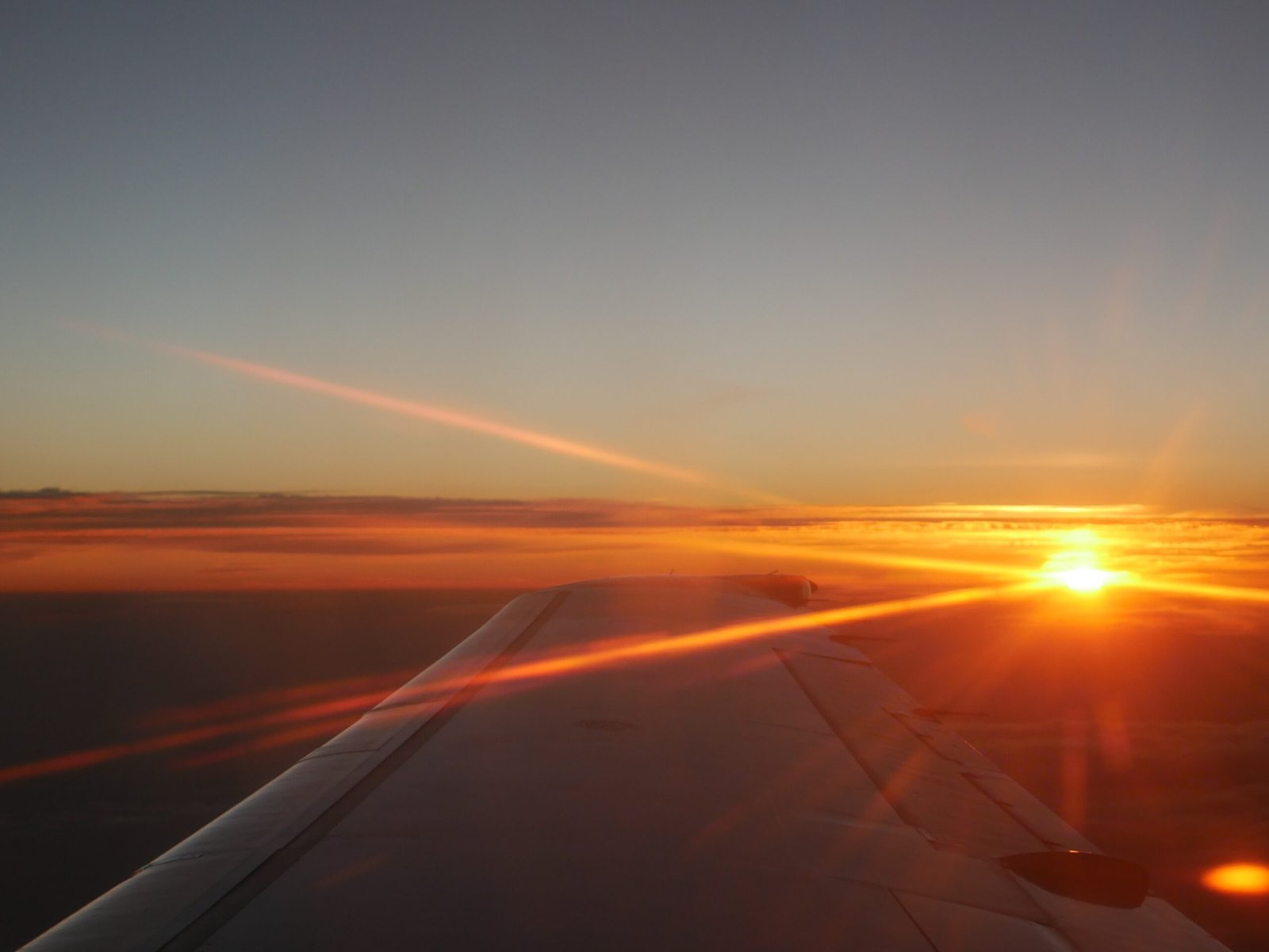 Picture of the sunrise form a plane, cresting over the horizon as I left my hometown of many years and embarked on a new journey.