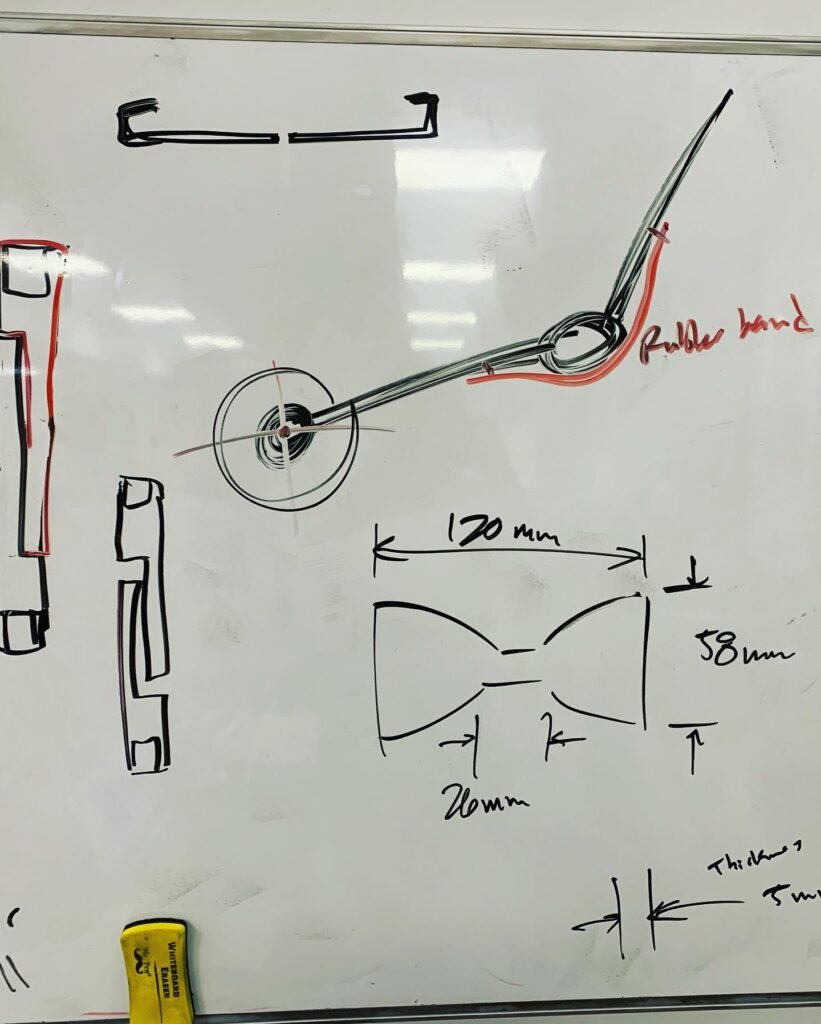 Whiteboard sketch of a bowtie and a robotic arm. 