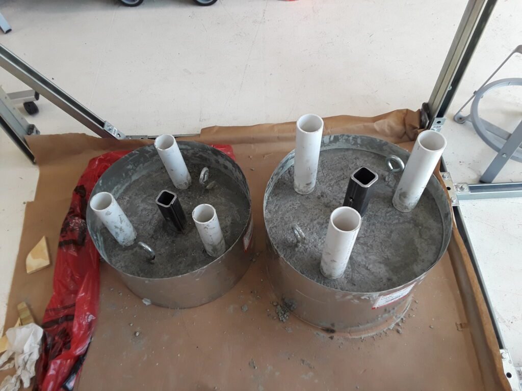 Simulated cargo and weight.  weights are made out of concrete to match the exact weights and have the correct center of mass. The PVC pipes are intended to provide attachment points for foam core to give the cargo their correct shape and dimensions to test other design requirements.