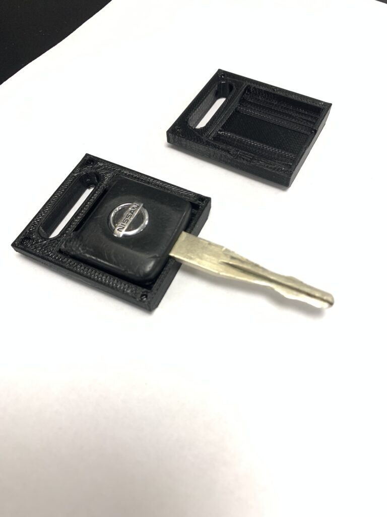 3D printed cover for a broken Nissan key. Two halves.