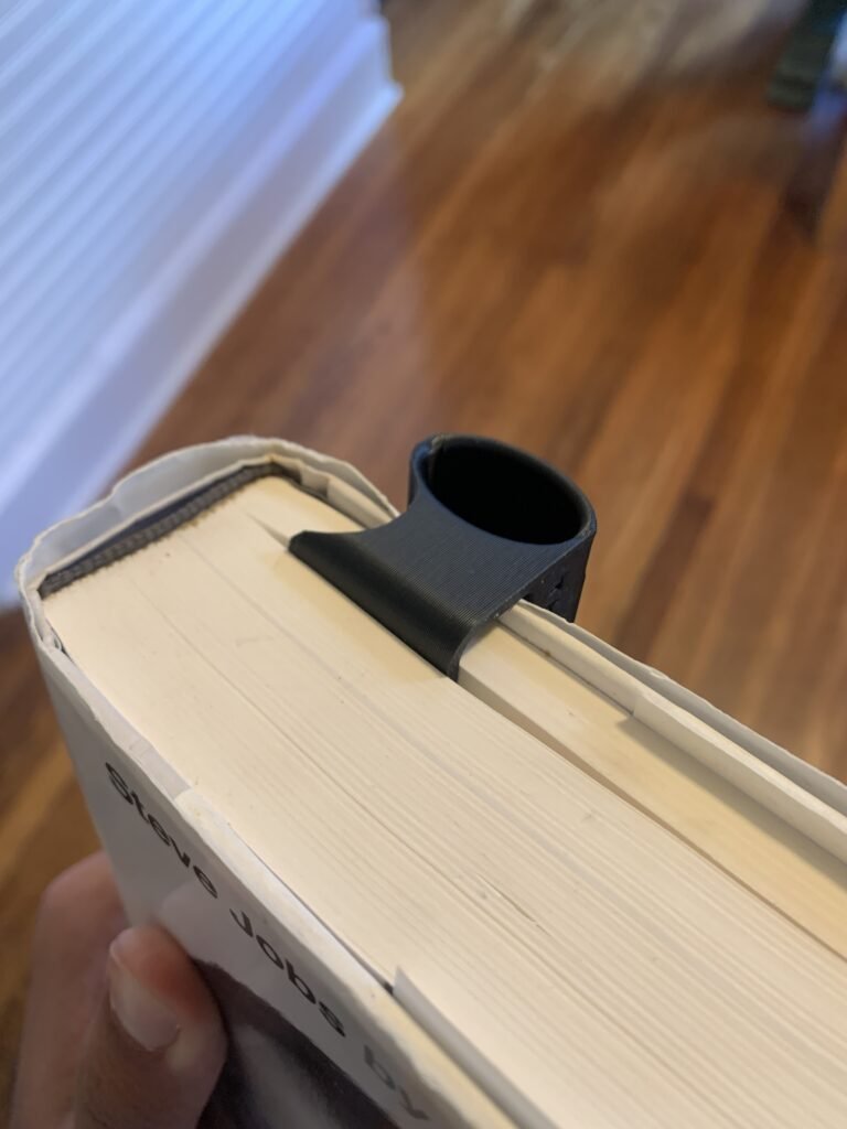 You’re probably wondering…why not simply clip your pen or highlighter to your book? If you’re anyone like me, you write a lot in a book and you prefer to read, when standing or sitting on the couch, or even on the toilet. So instead of setting my pen down on my chest or my ear, I designed an printed a holder that clips into any book and hold a pen and highlighter. 3D Printed Book Pen Holder with Steve Jobs by Walter Isaacson's book