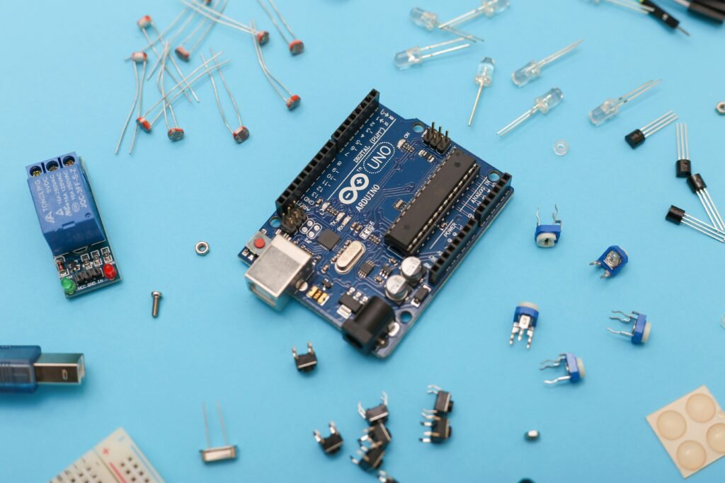 Arduino Uno and electronic parts on a blue surface.